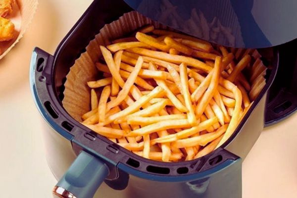 air fryer com batata frita e forro de papel